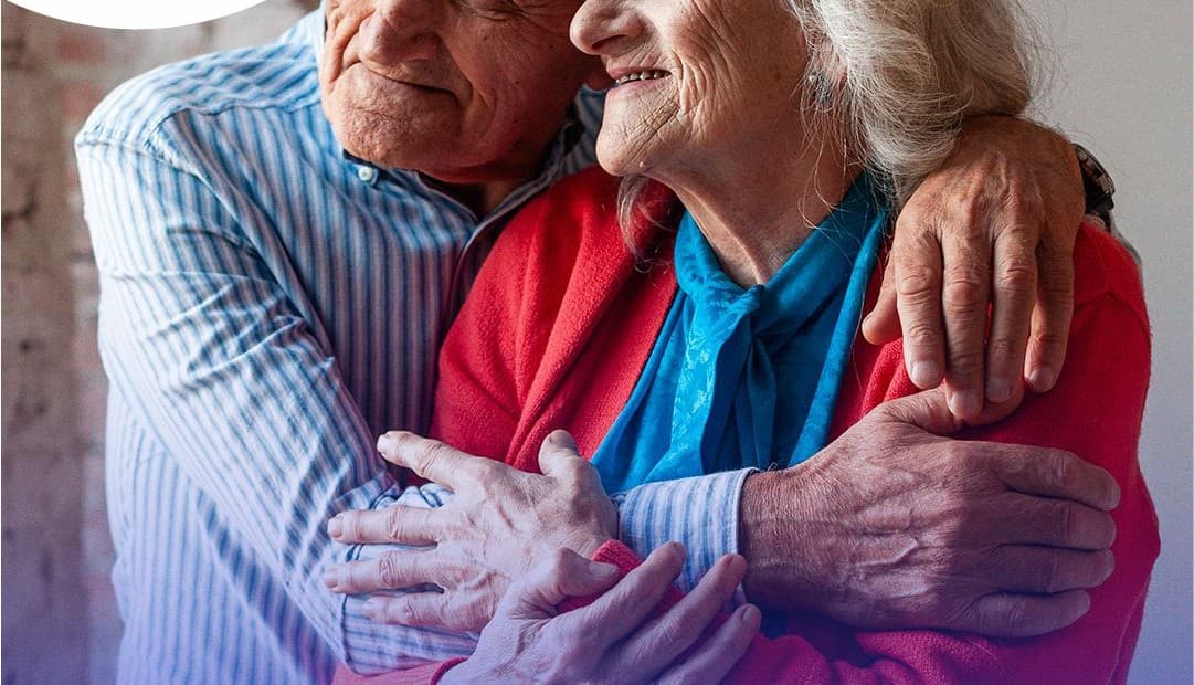 Casal de idosos abraçados sorrindo
